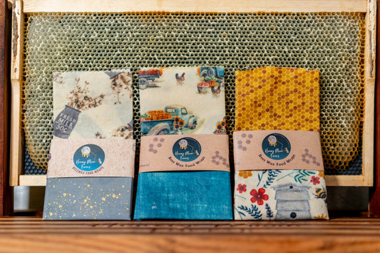 A selection of colorful beeswax food wraps displayed in a honeycomb-patterned box.